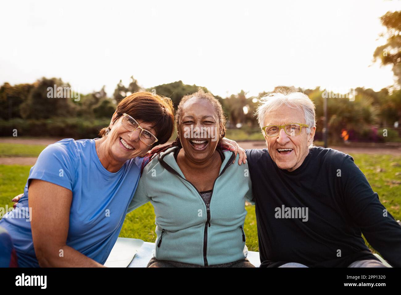 Happy multiracial senior friends having fun smiling at the camera after training activities in the park Stock Photo