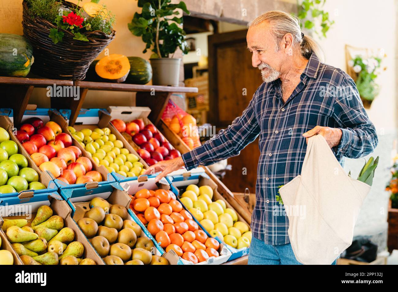 Happy senior man buying fresh fruits at the market - Shopping food concept Stock Photo