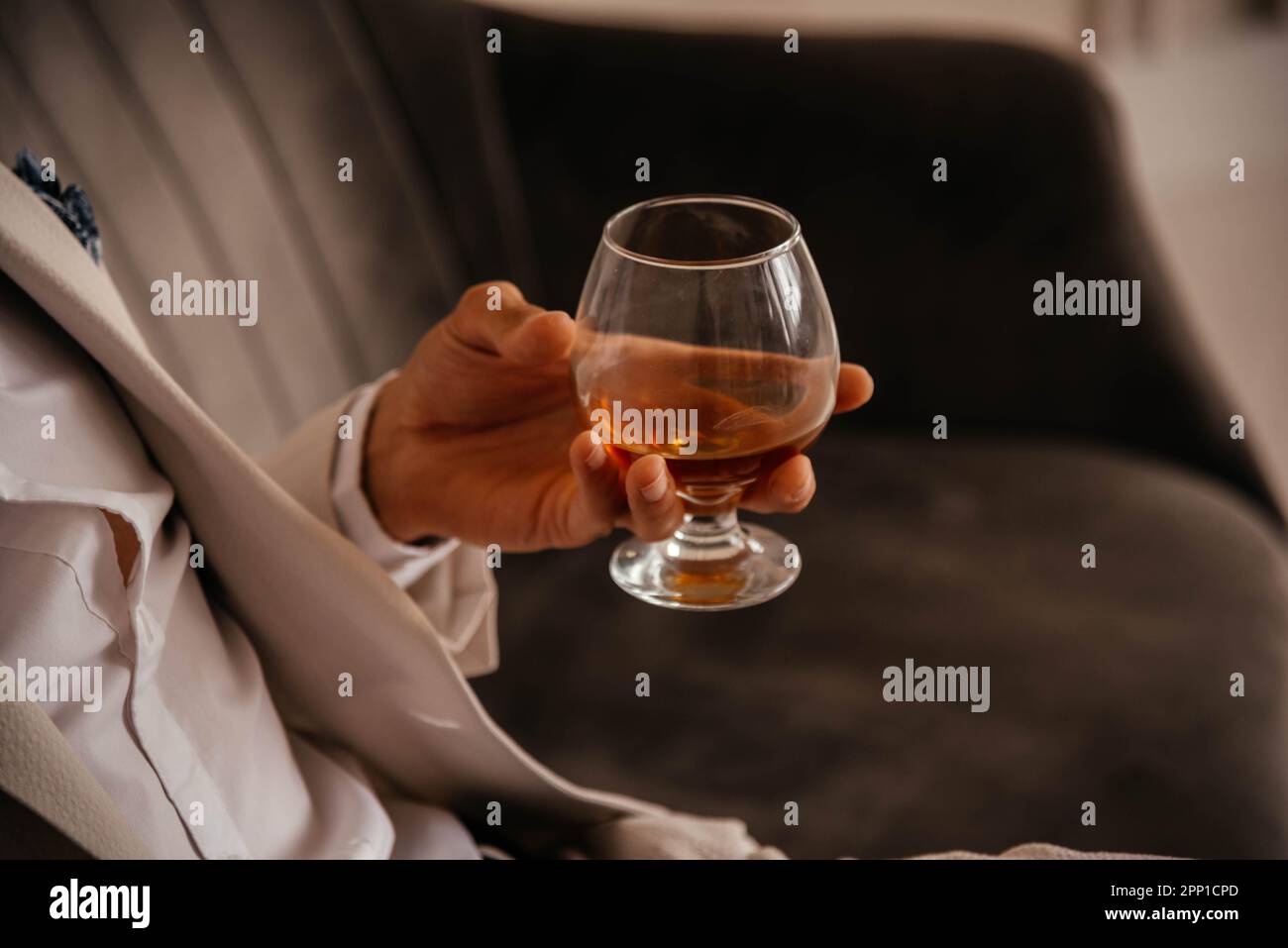 A glass of cognac in a man's hand.  Stock Photo