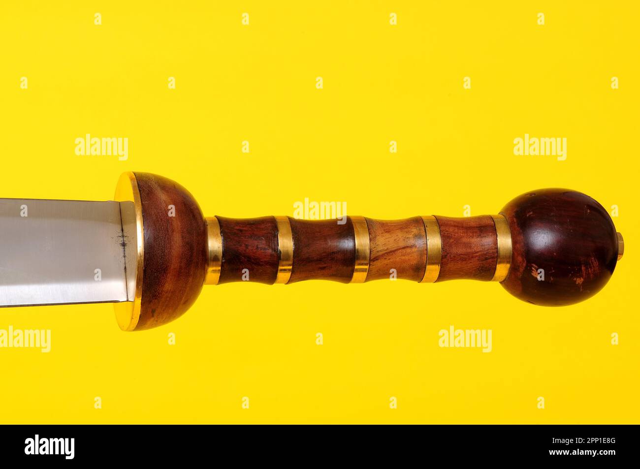 Gladius sword blade, guard, and hilt isolated over yellow Stock Photo