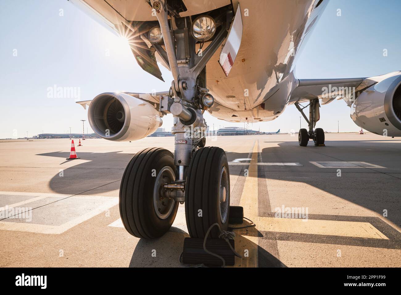 Low angle view of airplane at airport. Preparation passenger plane before flight during sunny summer day. Stock Photo