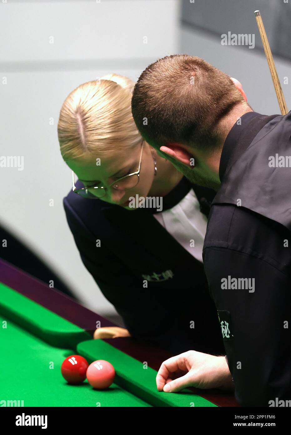 Mark Allen (right) and referee Desislava Bozhilova inspect a red and the pink during the match against Stuart Bingham during day seven of the Cazoo World Snooker Championship at the Crucible Theatre,