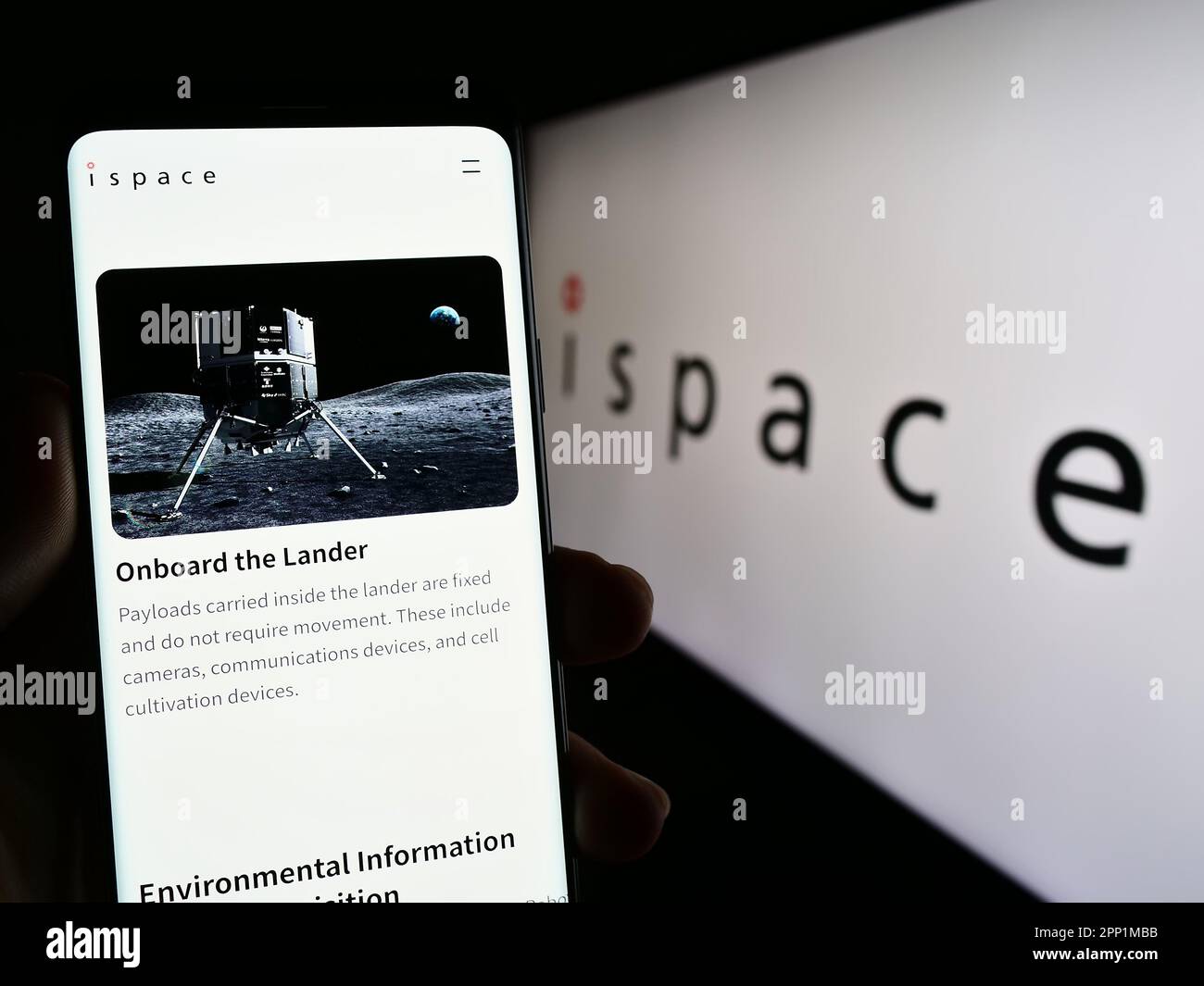 Person holding smartphone with web page of Japanese aerospace company ispace Inc. on screen in front of logo. Focus on center of phone display. Stock Photo