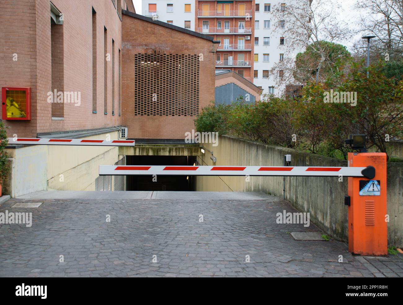 Parking entrance with orange bar access on the street Stock Photo