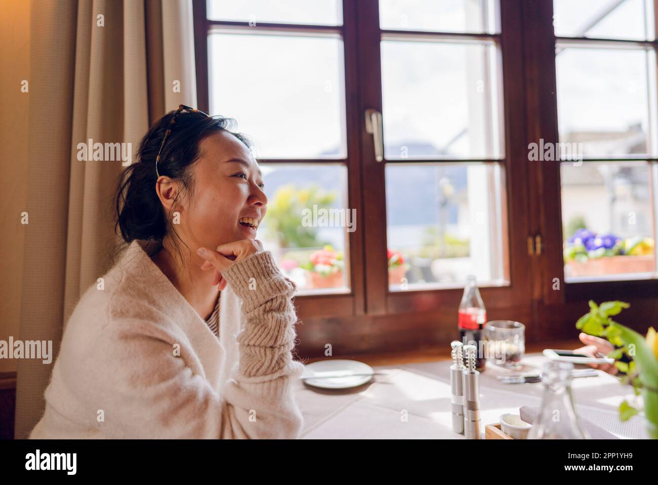 A woman at a dining table by the window Stock Photo Alamy