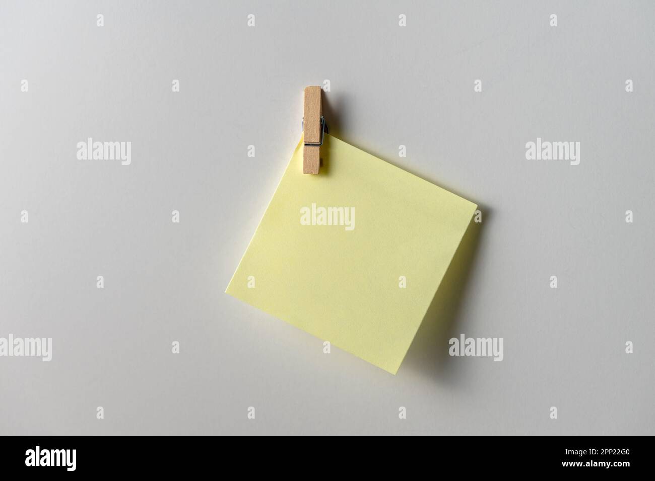Yellow note paper on white background. Copy space. Close up. Stock Photo