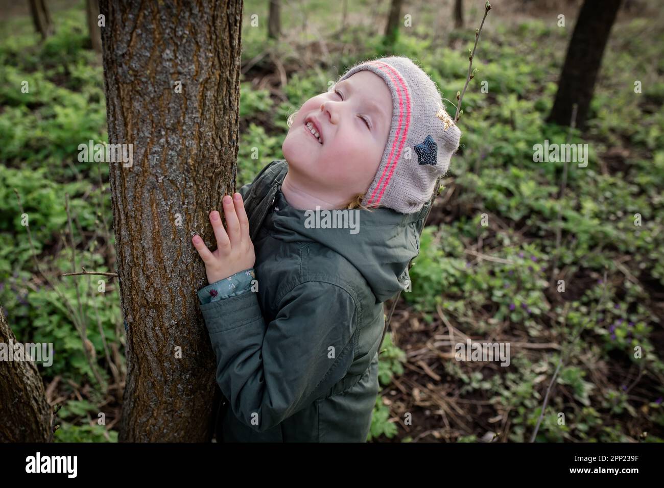 Hugging a tree: the girl feels calm and harmonious, enjoying forest ...