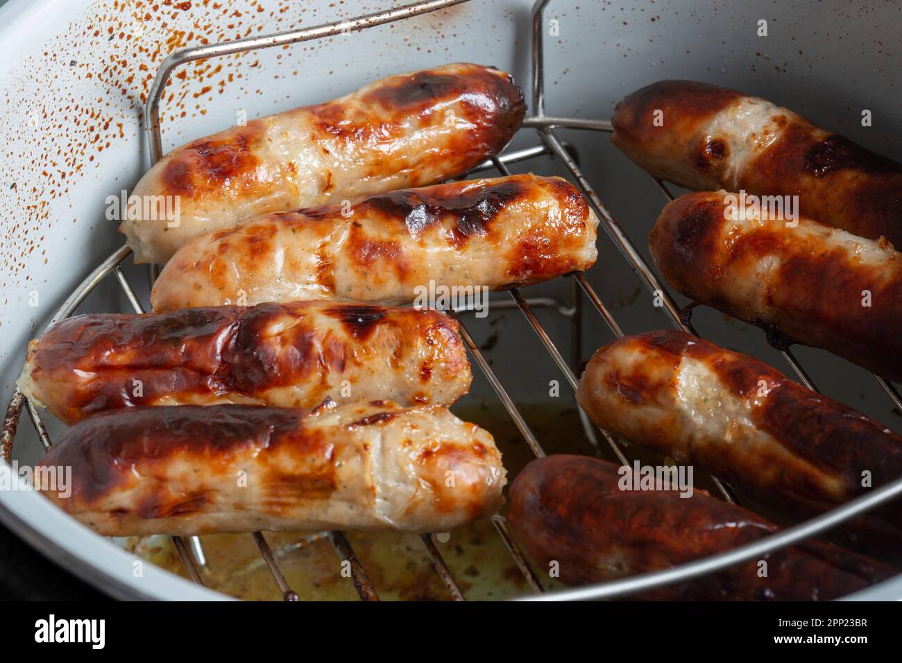 Pork sausages on a rack cooked in an air fryer. Healthy low cost