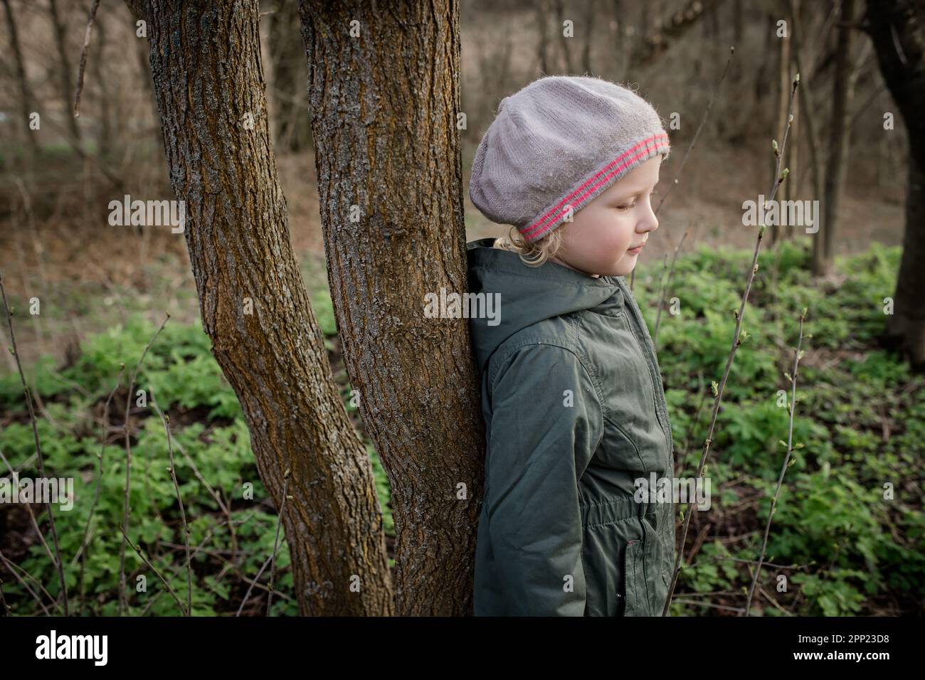 energy of tree: girl charged with positive energy of tree, feeling interaction with nature and support from environment. Tree therapy concept, Shinrin Stock Photo