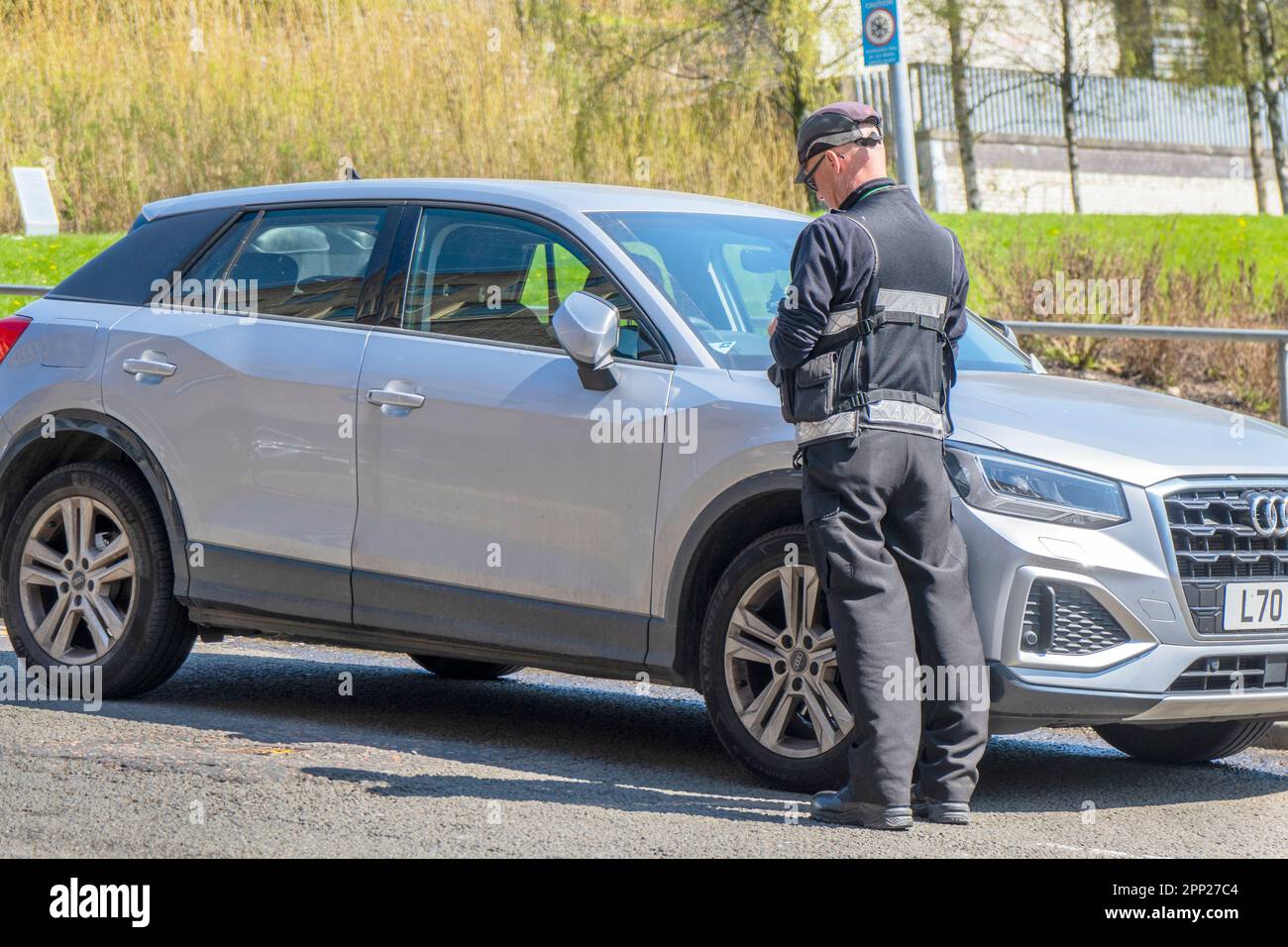 Traffic Warden issuing a parking ticket to a car illegally parked near Glasgow city centre, Scotland, UK Stock Photo