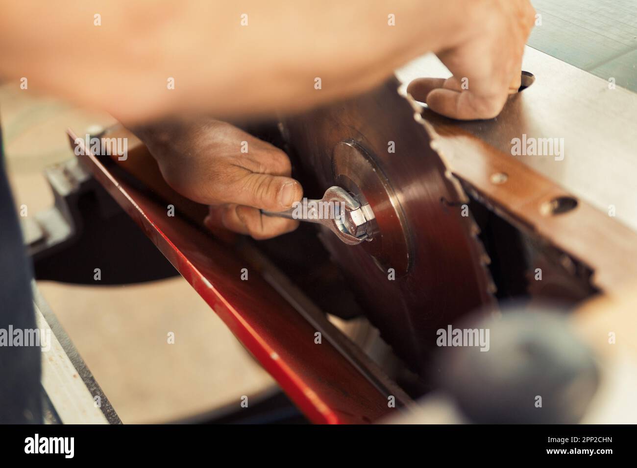 A detail shot of a wrench tightening a nut to secure a circular saw