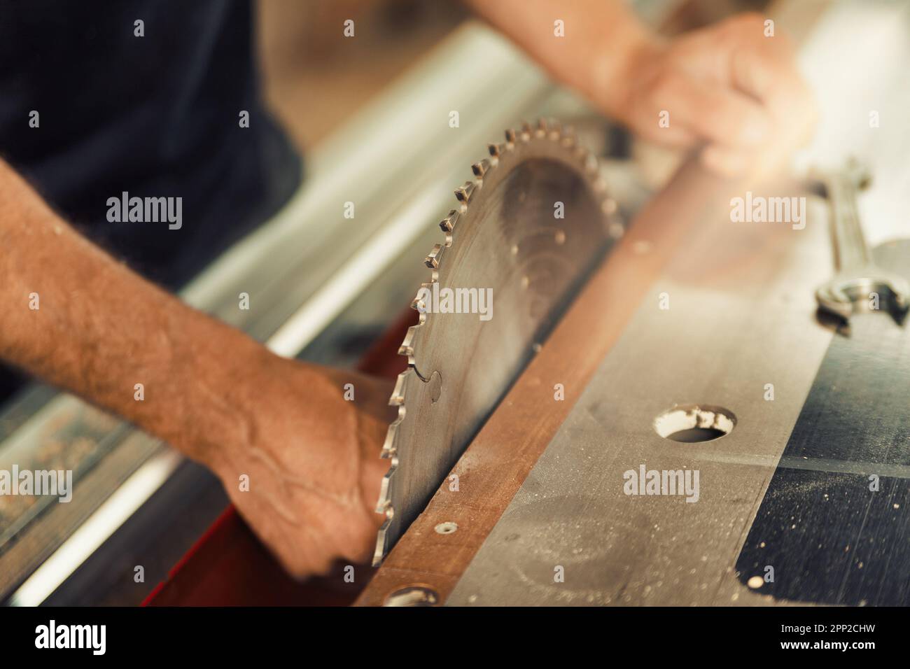 A close-up shot in focus of the toothed blade of a circular saw stopped for setup by the carpenter. Being a skilled artisan in this century means usin Stock Photo