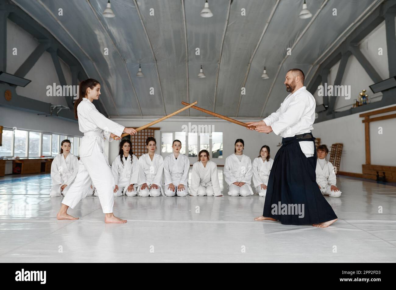 Martial arts master teaching young student to fight with wooden sword Stock Photo