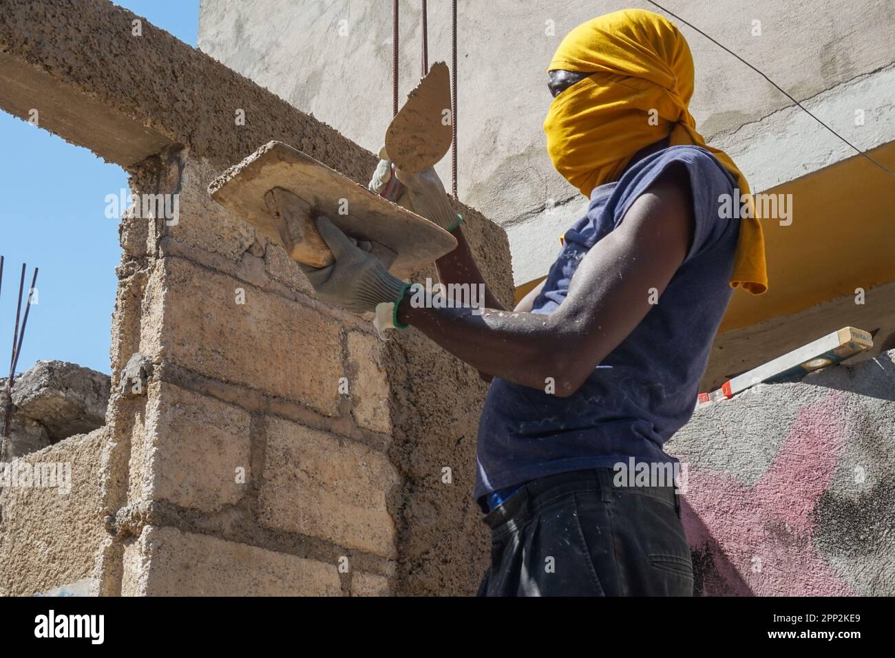 Dary Pierre cements a wall in Carrefour, Port-au-Prince, Haiti on Feb. 19, 2023. Pierre, who has worked as a builder for four years, says the skills have provided professional opportunities and helped him build his own house. (Anne Myriam Bolivar/Global Press Journal) Stock Photo