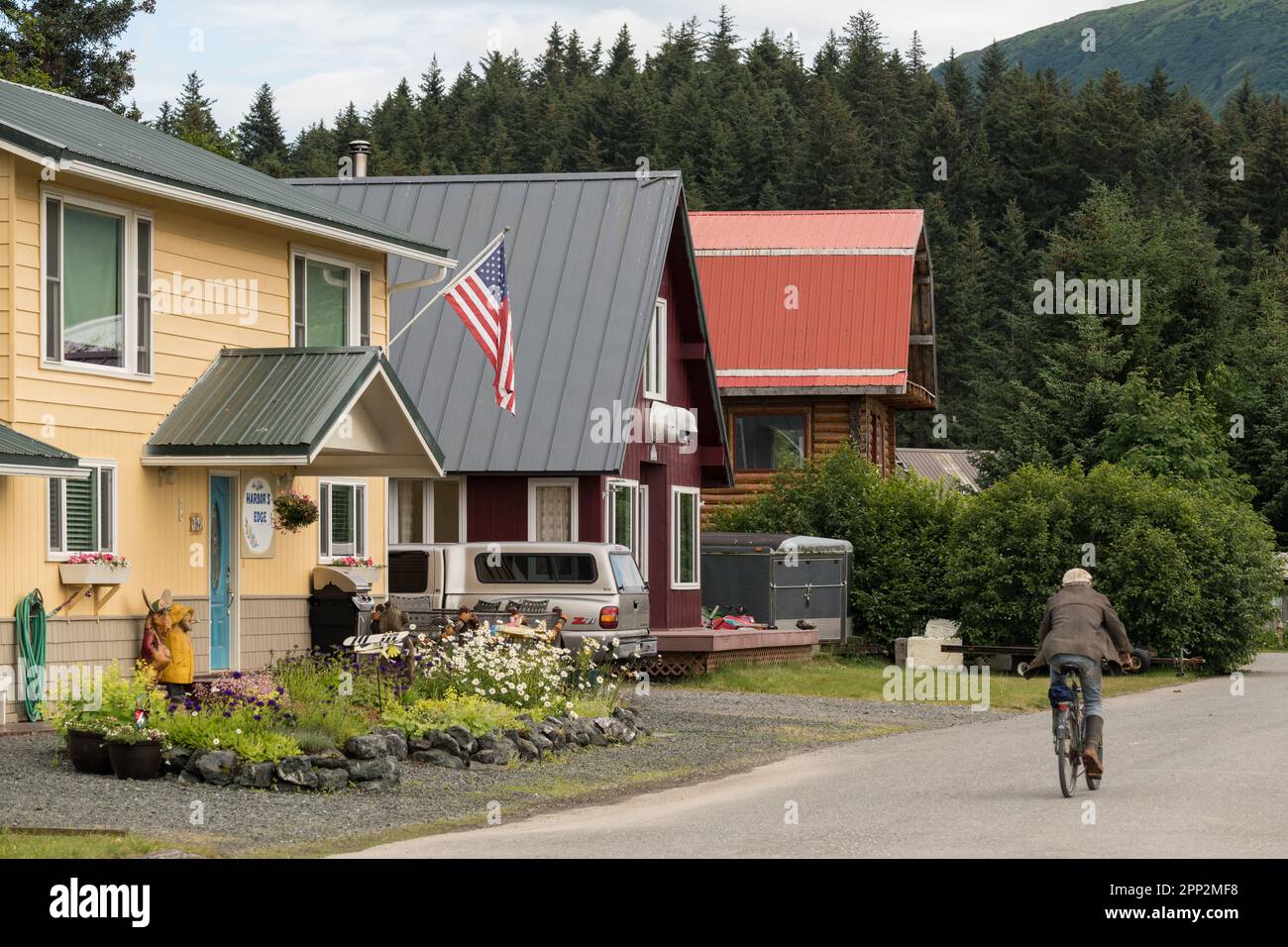 A man rides a bicycle past homes on Main Street in the remote hamlet of