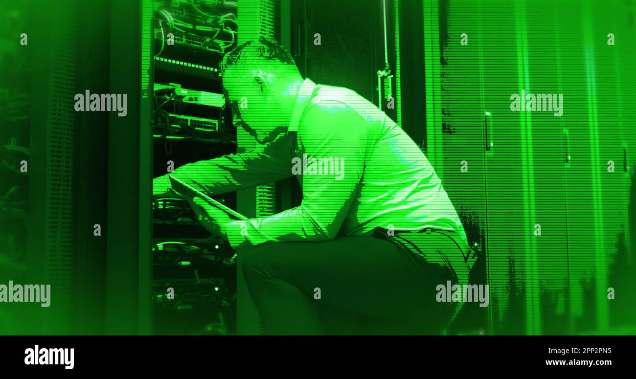 Composition of interference over caucasian businessman using tablet in server room Stock Photo