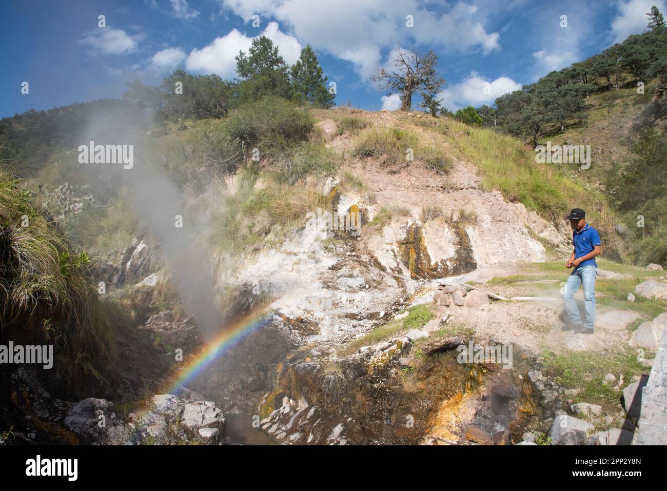 Emilio Rascón Nuñez stands near a geyser in Maguarichi, Chihuahua, Mexico on Oct. 1, 2022. Throughout the municipality, at least 96 geysers form cascades along the stream, some with temperatures over 98 degrees Celsius (208.4 degrees Fahrenheit) and heights of more than 4 meters (13.1 feet). (Lilette A. Contreras/Global Press Journal) Stock Photo