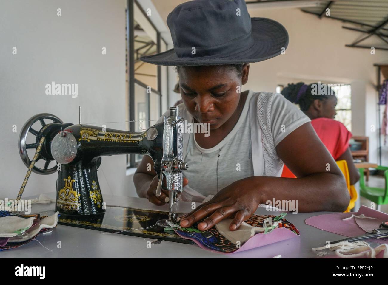 Likeness Lusybwe sews a reusable sanitary pad at the Jafuta Foundation in Victoria Falls, Zimbabwe on Oct. 19, 2022. Various organizations in Zimbabwe make reusable sanitary wear for girls who can’t afford it, so they don’t miss classes when menstruating. (Fortune Moyo/Global Press Journal) Stock Photo