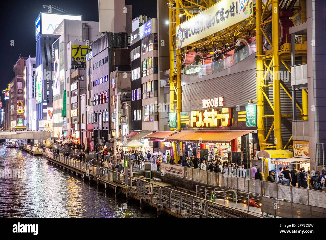 Osaka Japan April 2023, Dotonbori River canal at night time with neon lights and crowds gathering for dinner and entertainment, street scene,Japan Stock Photo