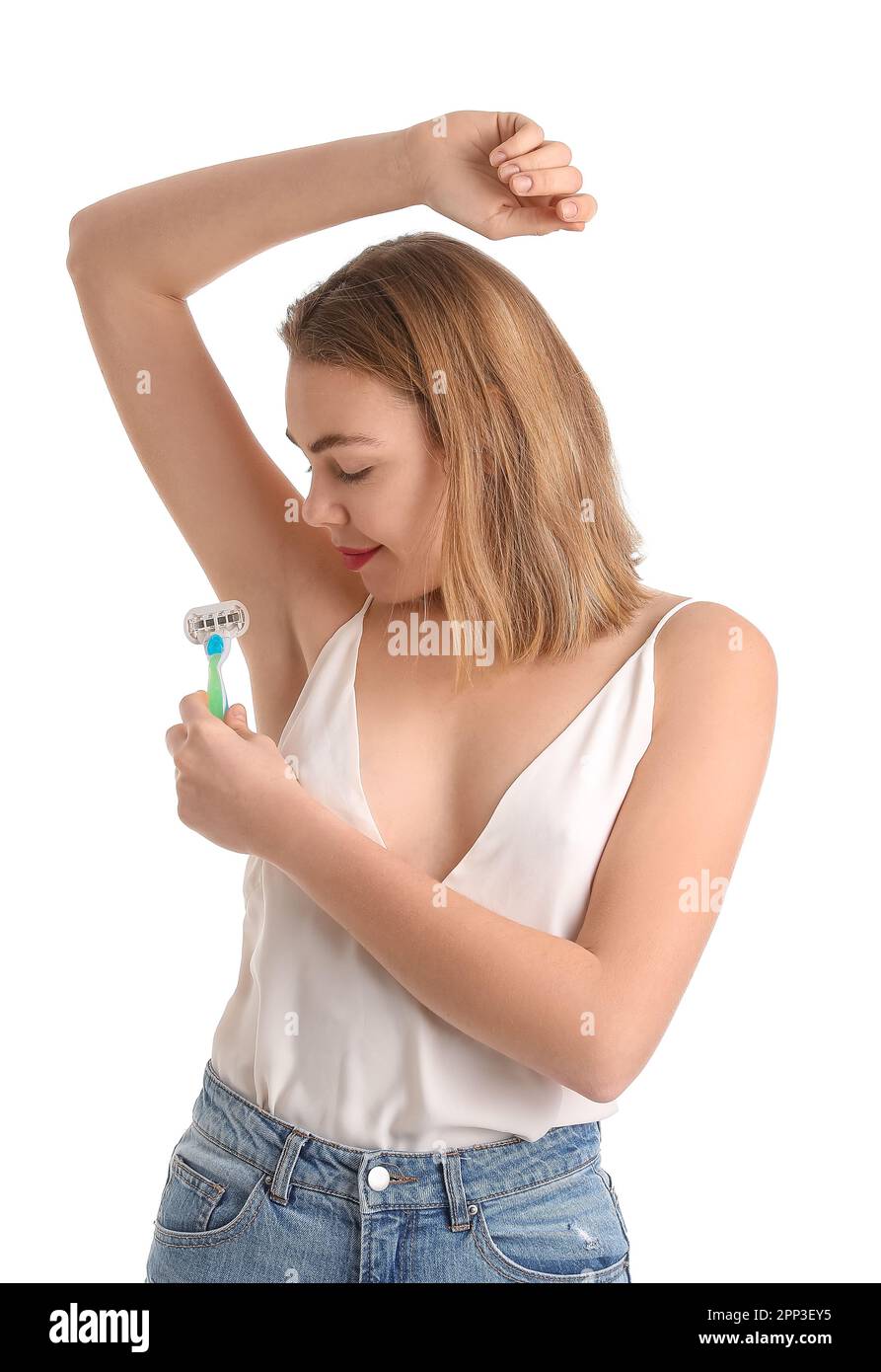 Young woman shaving armpits with razor on white background Stock Photo