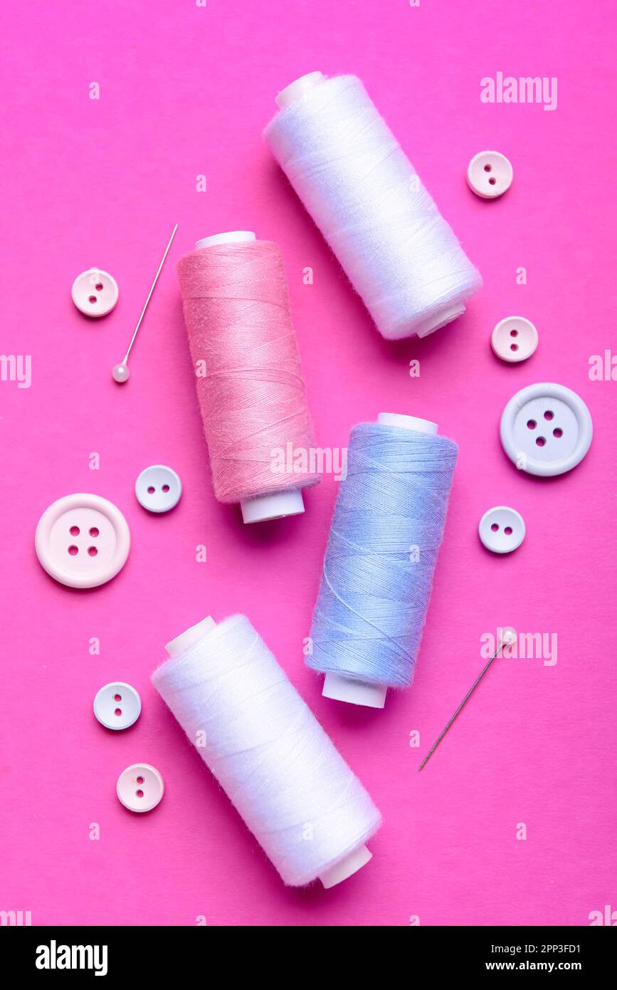 Composition with thread spools, buttons and ball pins on color background Stock Photo
