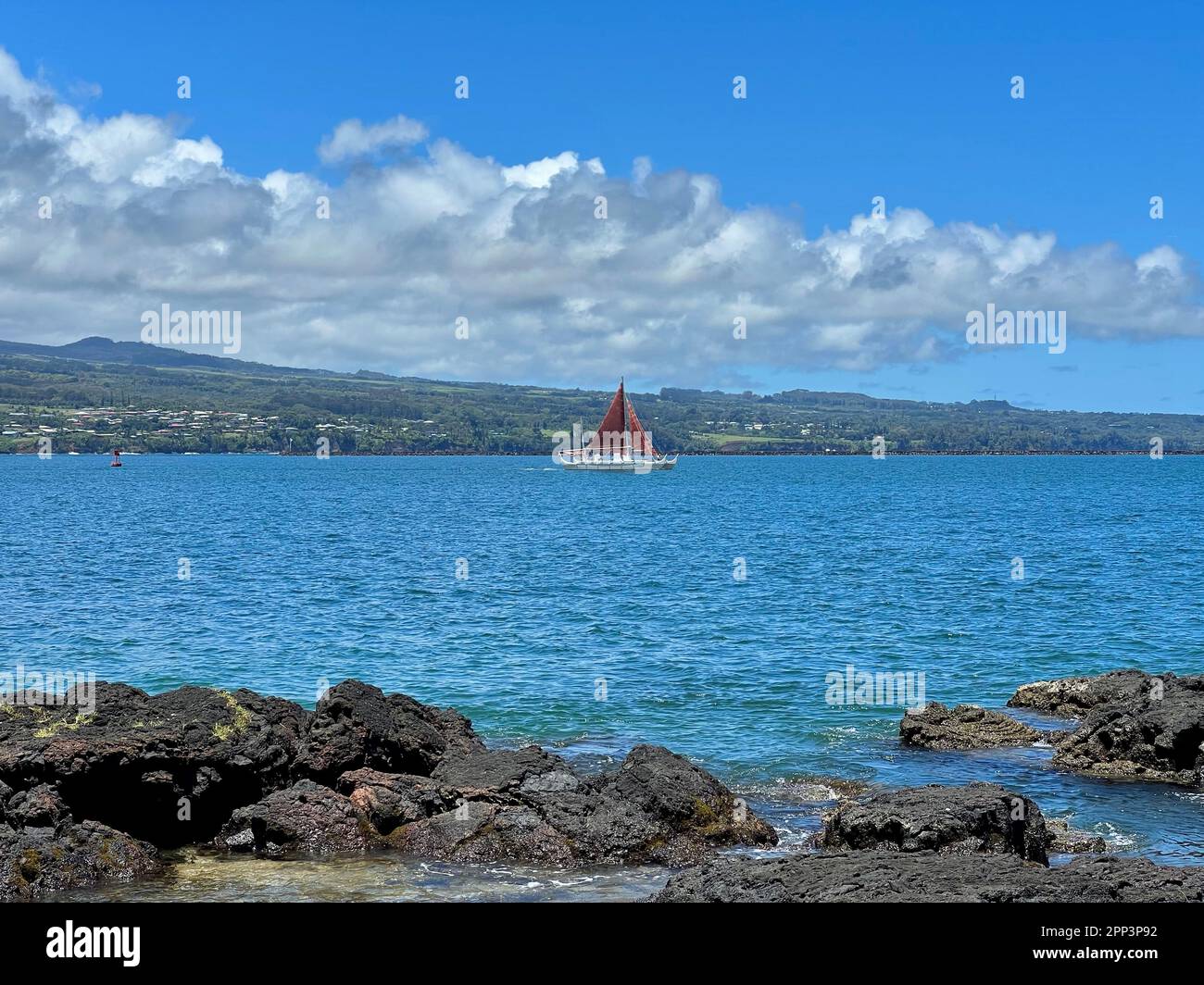 Ancient polynesian outrigger sailing canoe in the Bay of Hilo in Hawaii Stock Photo