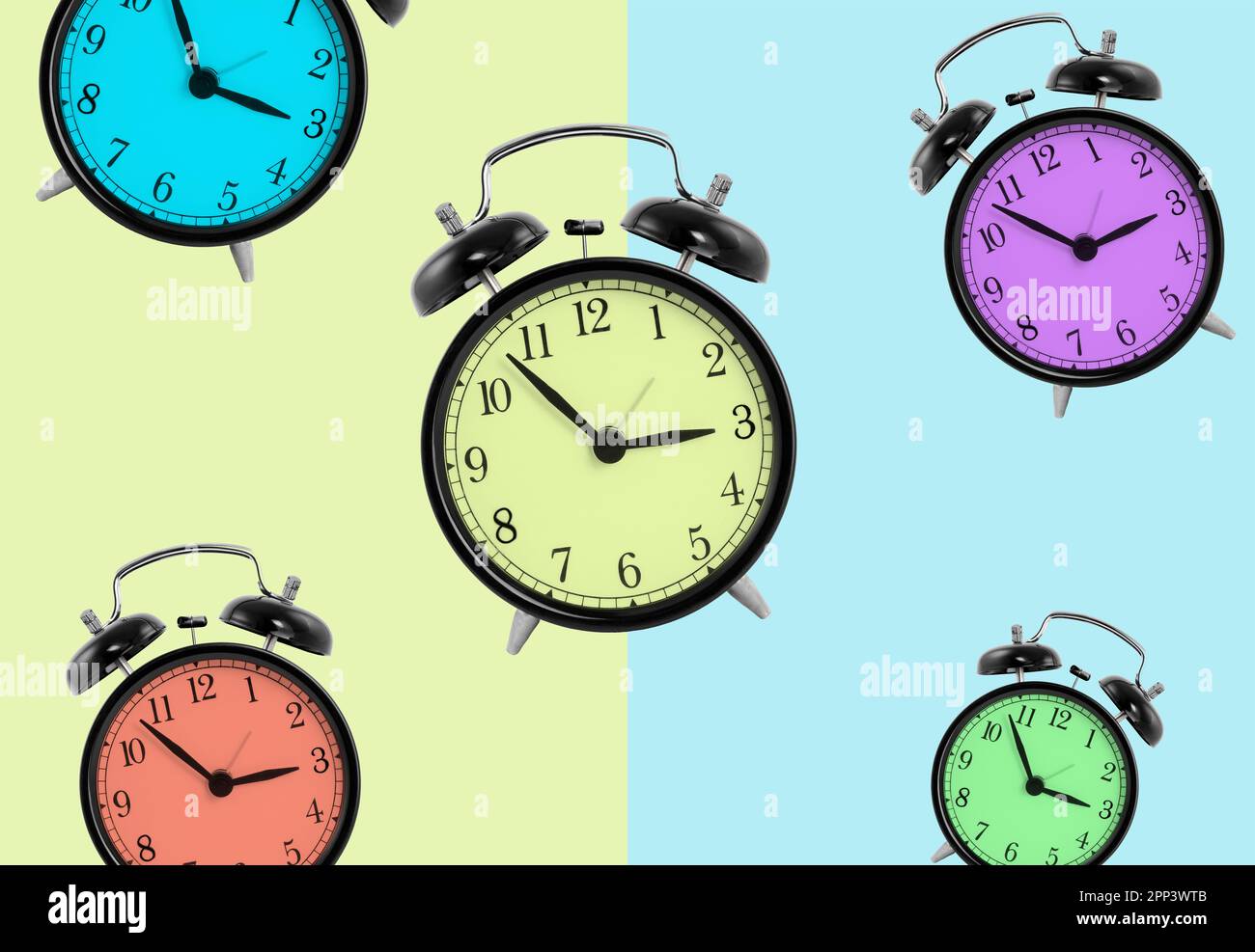 Clocks with different colors isolated on green and blue background Stock Photo