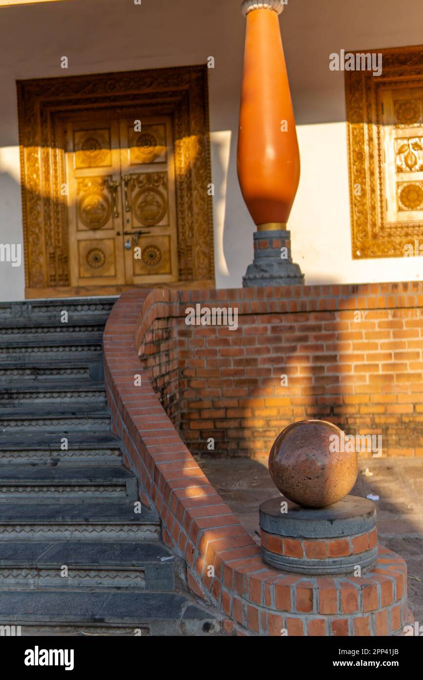 Outdoor main staircase with stone stairs and natural wood rails. A big spherical wooden ball forms the edge of the rails in a traditional Tamil, Keral Stock Photo