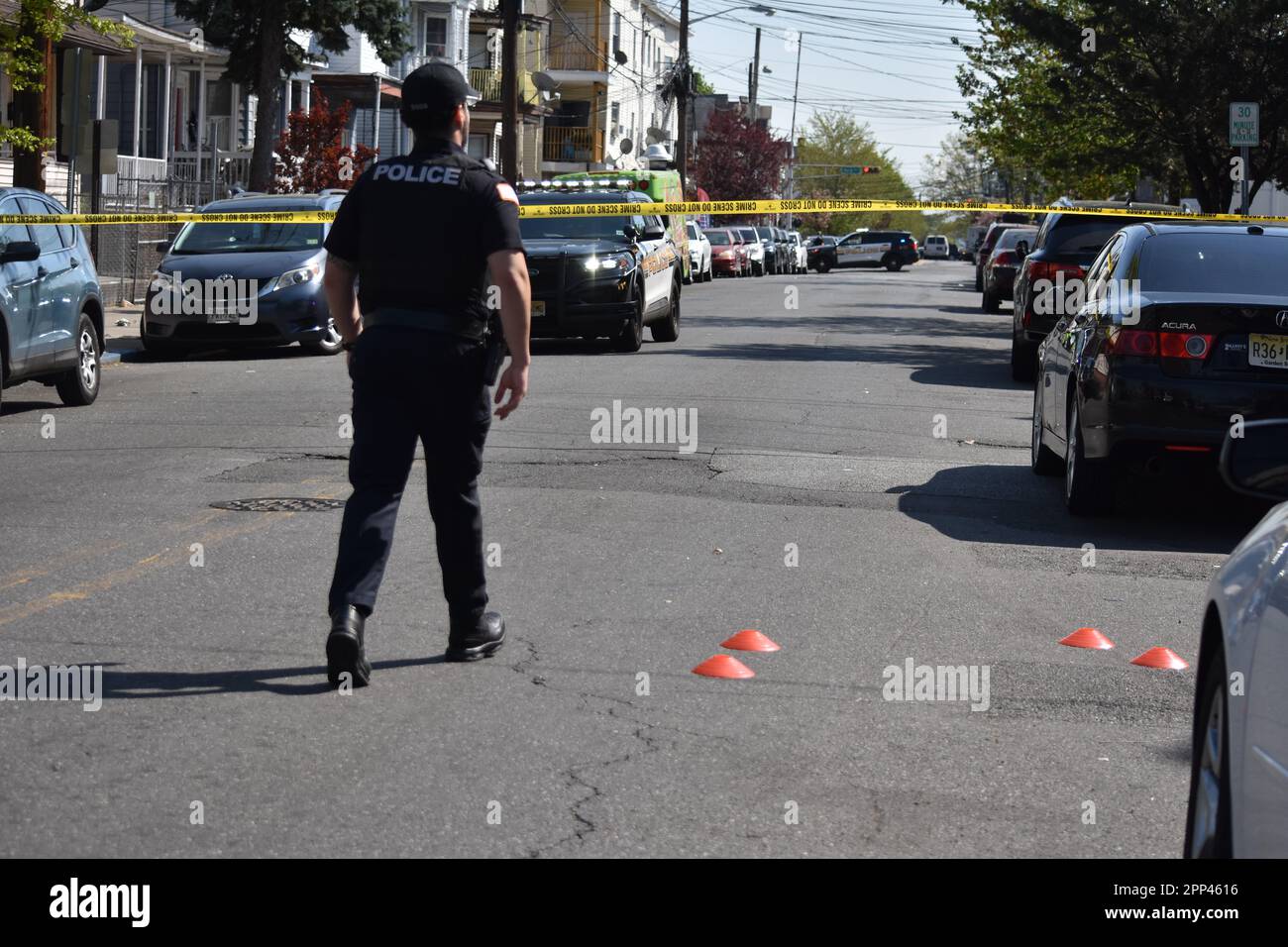 Police officer overlooks the crime scene as evidence markers litter the