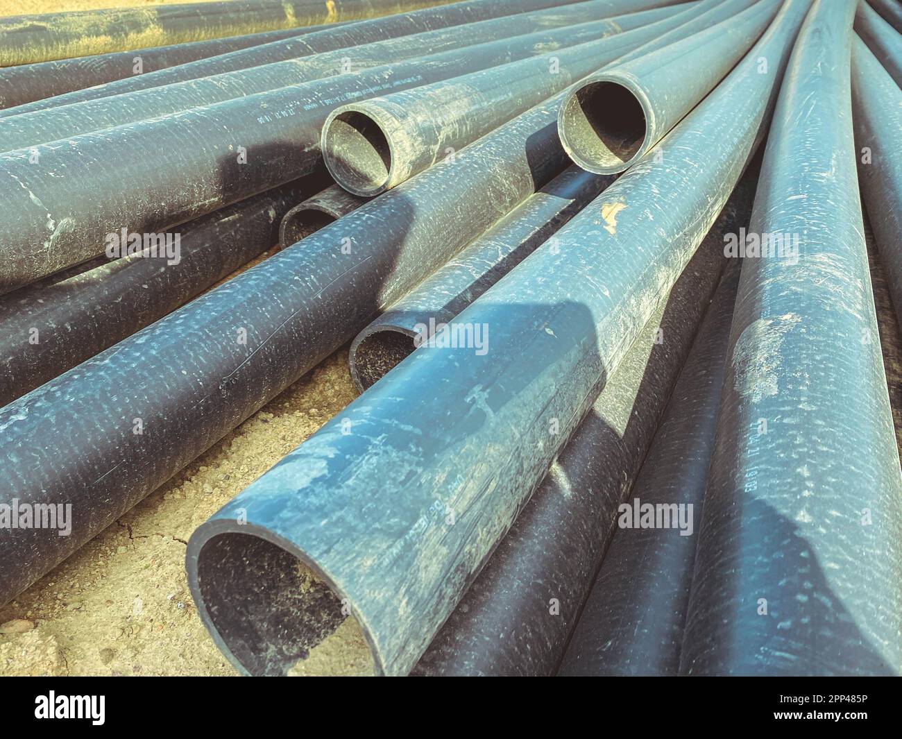 black pipes lie on the ground. laying communications for residential