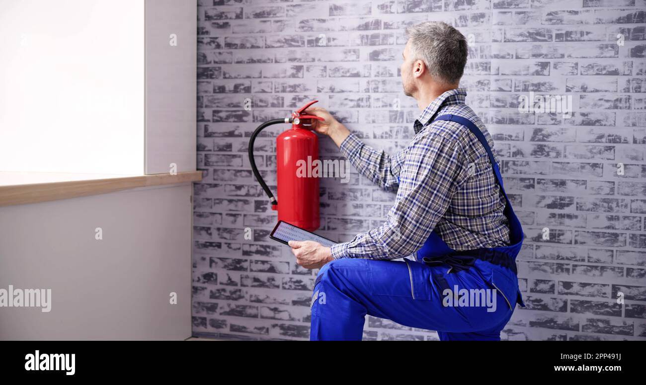 Worker Installing Fire Extinguisher. Inspection Service. Checking Security Label Stock Photo Alamy