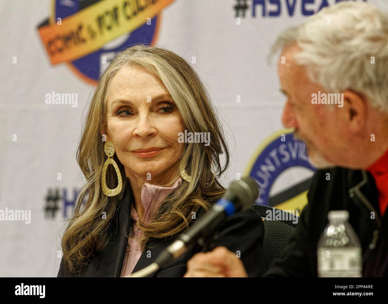 Huntsville, Alabama, USA. 21 Apr 2023. Star Trek actress Gates McFadden (left) smiles while listening to castmate John de Lancie during a Star Trek: The Next Generation panel on the first day of the 2023 Huntsville Comic & Pop Culture Expo on Friday, April 21, 2023 at the Von Braun Center in Huntsville, Madison County, AL, USA. McFadden, 74, most recently reprised her role as 'Dr. Beverly Crusher' in the Star Trek: Picard series finale which premiered the day before this appearance. (Credit: Billy Suratt/Apex MediaWire via Alamy Live News) Stock Photo