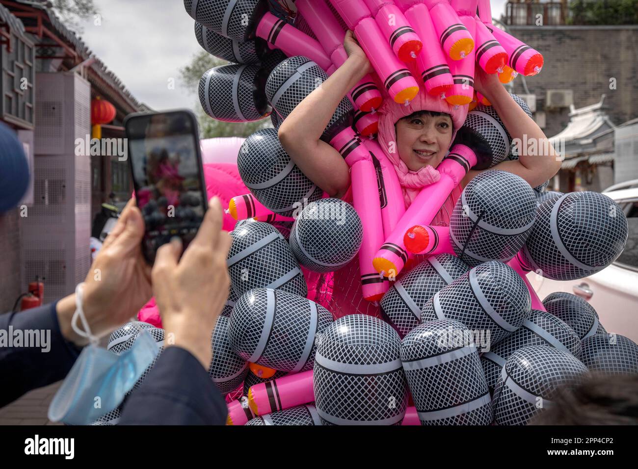 Artist Kong Ning poses for photos as she wears her latest work "Sing ...