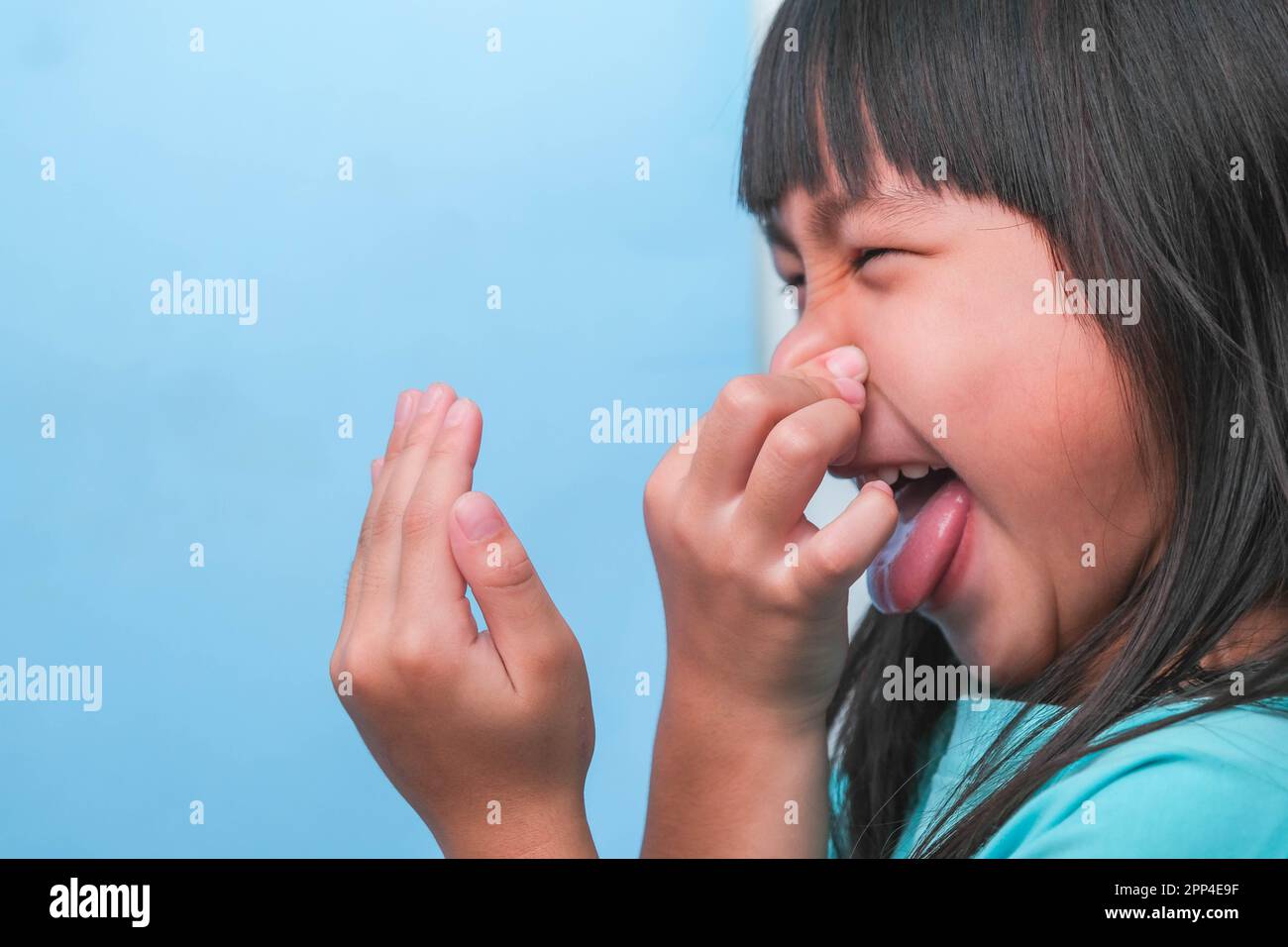 Little girl covering mouth with hand hires stock photography and