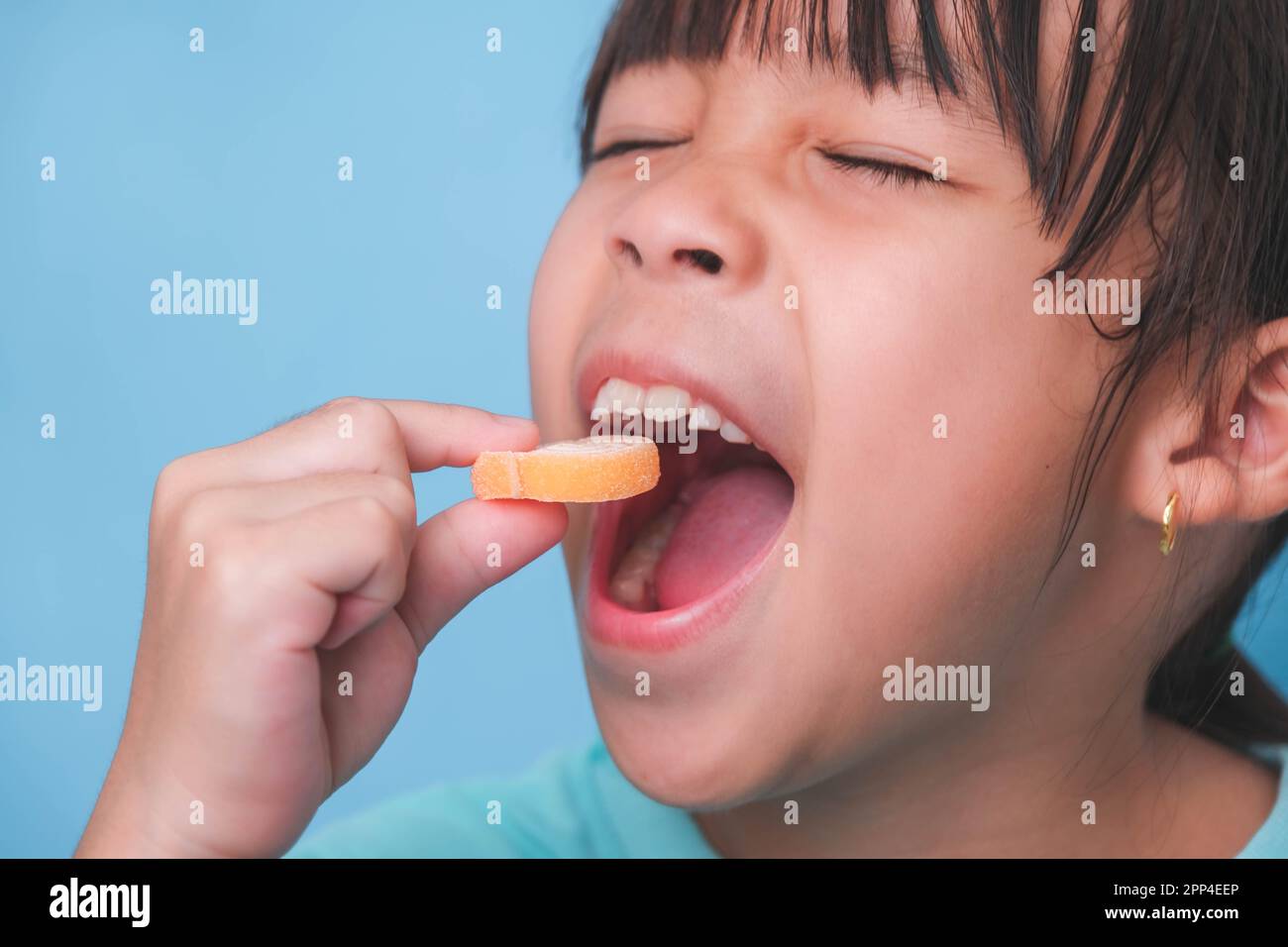 Smiling cute little girl eating sweet gelatin with sugar added isolated
