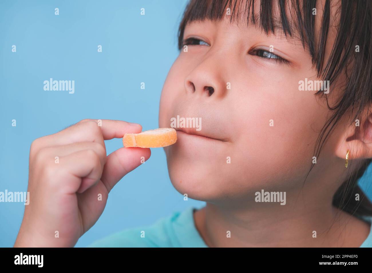 Smiling cute little girl eating sweet gelatin with sugar added isolated