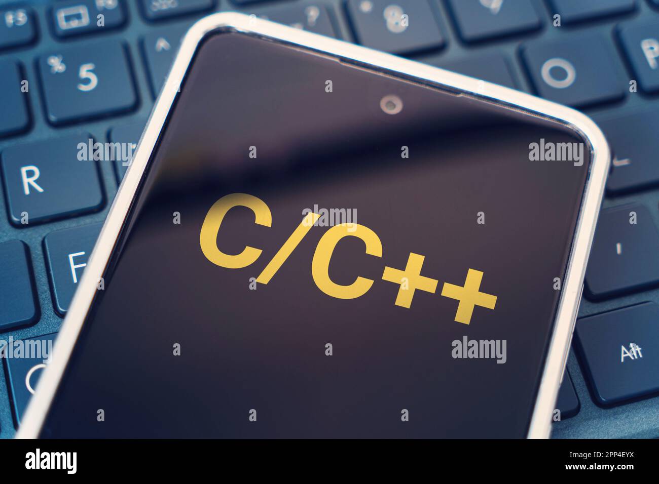 C Programming language for mobile development, concept. Smartphone on the laptop keyboard, the programmer workplace. inscription on the mobile phone s Stock Photo