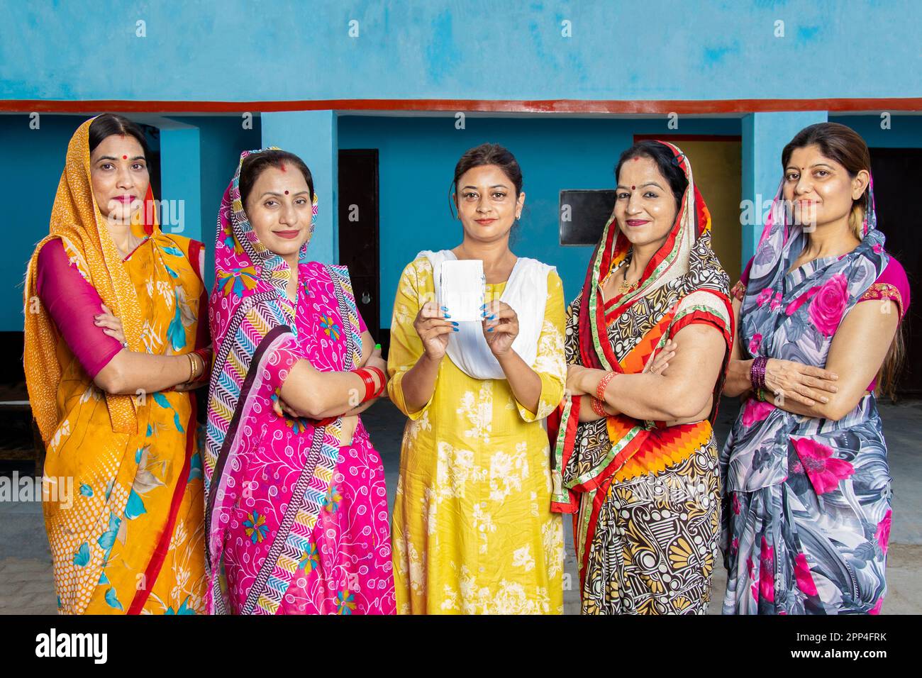 Young indian woman holding sanitary pad in hand standing with other