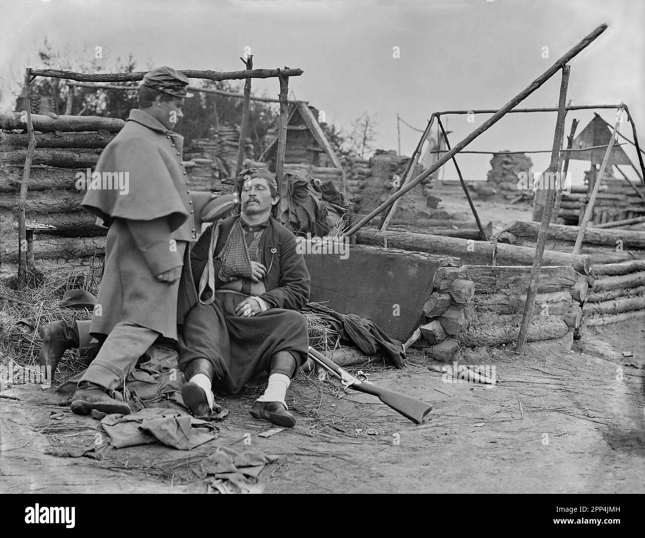 Scene showing deserted camp and wounded Zouave soldier. Circa 1860-65. The Zouave soldier is wearing a Silver Crescent and Star Badge. Stock Photo
