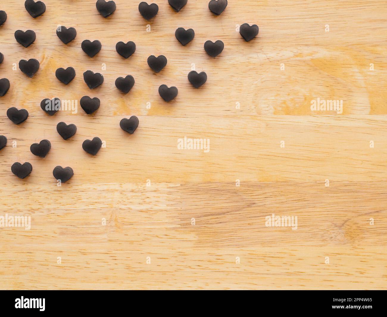 black heart shape made from candle on wooden table Stock Photo