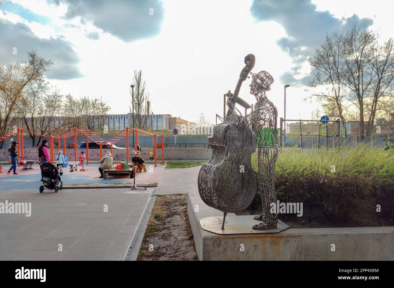 04-19-2023  Moscow, Russia. Metal wire statue  (musucian with contrabus) next to skysrapers of  'Savelovsky' district  next to metro Dmitrovskaya.  Ap Stock Photo