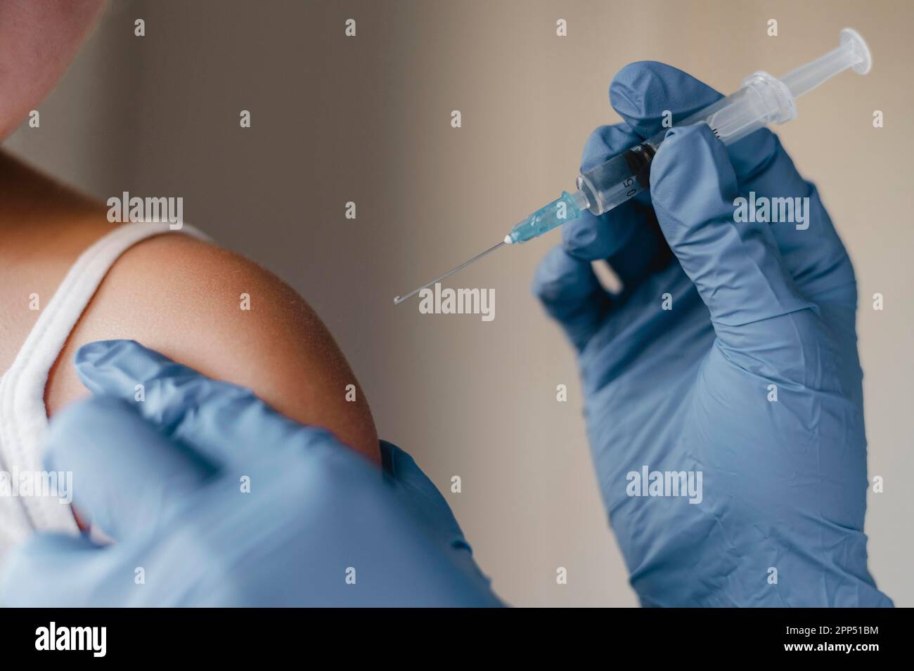 Doctor with gloves administering little child vaccine Stock Photo