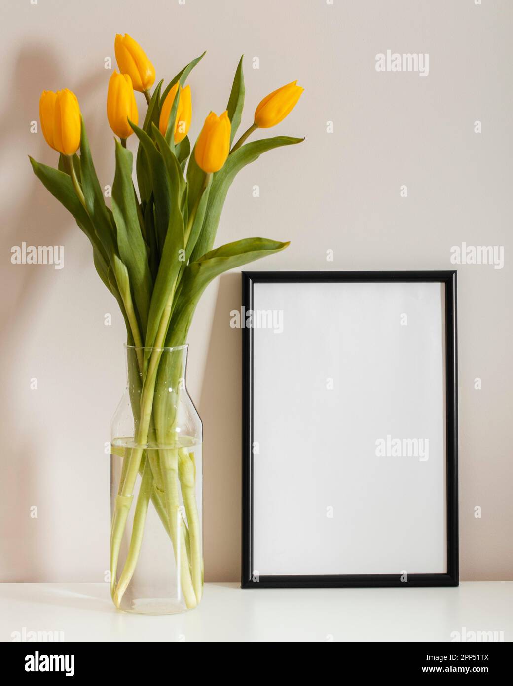 Front view bouquet tulips vase with empty frame Stock Photo