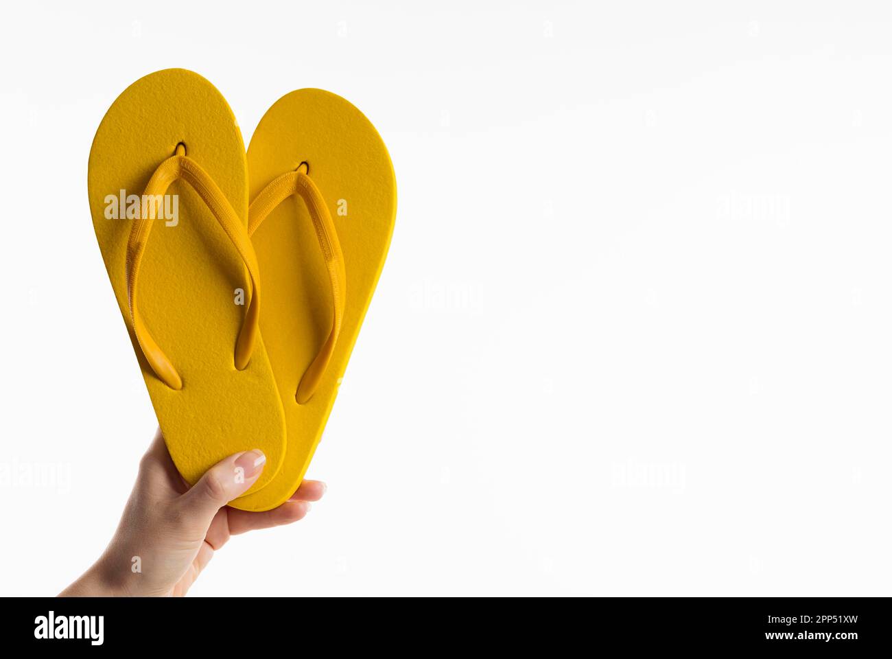 Front view hand holding flip flops Stock Photo