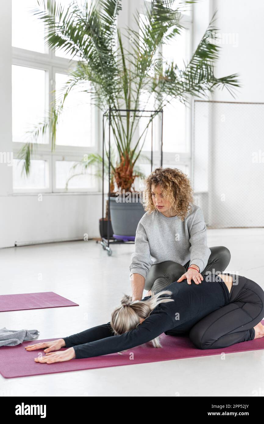 Full shot woman stretching with teacher Stock Photo