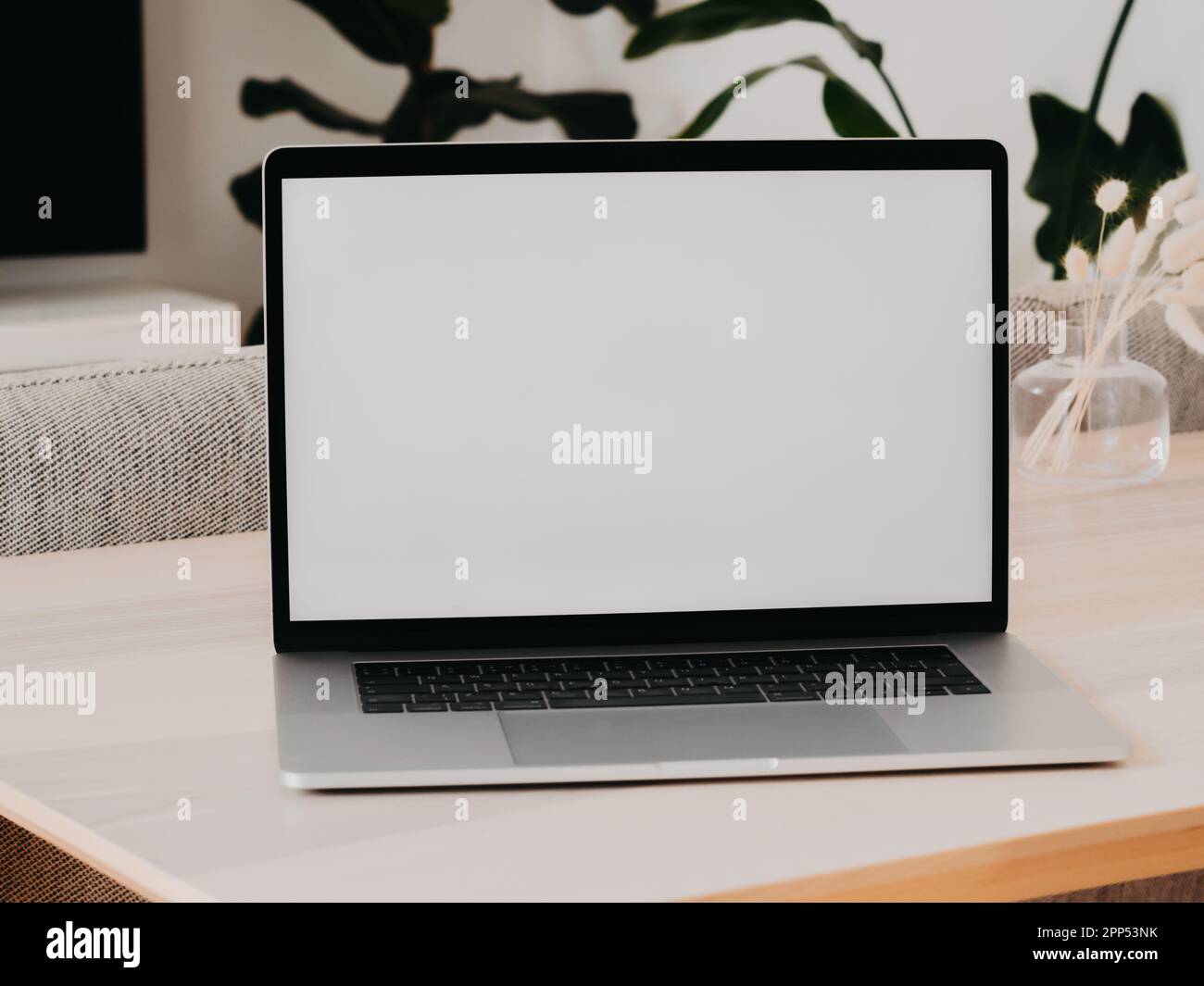 Laptop with blank screen on wooden table in home interior. Workplace ...