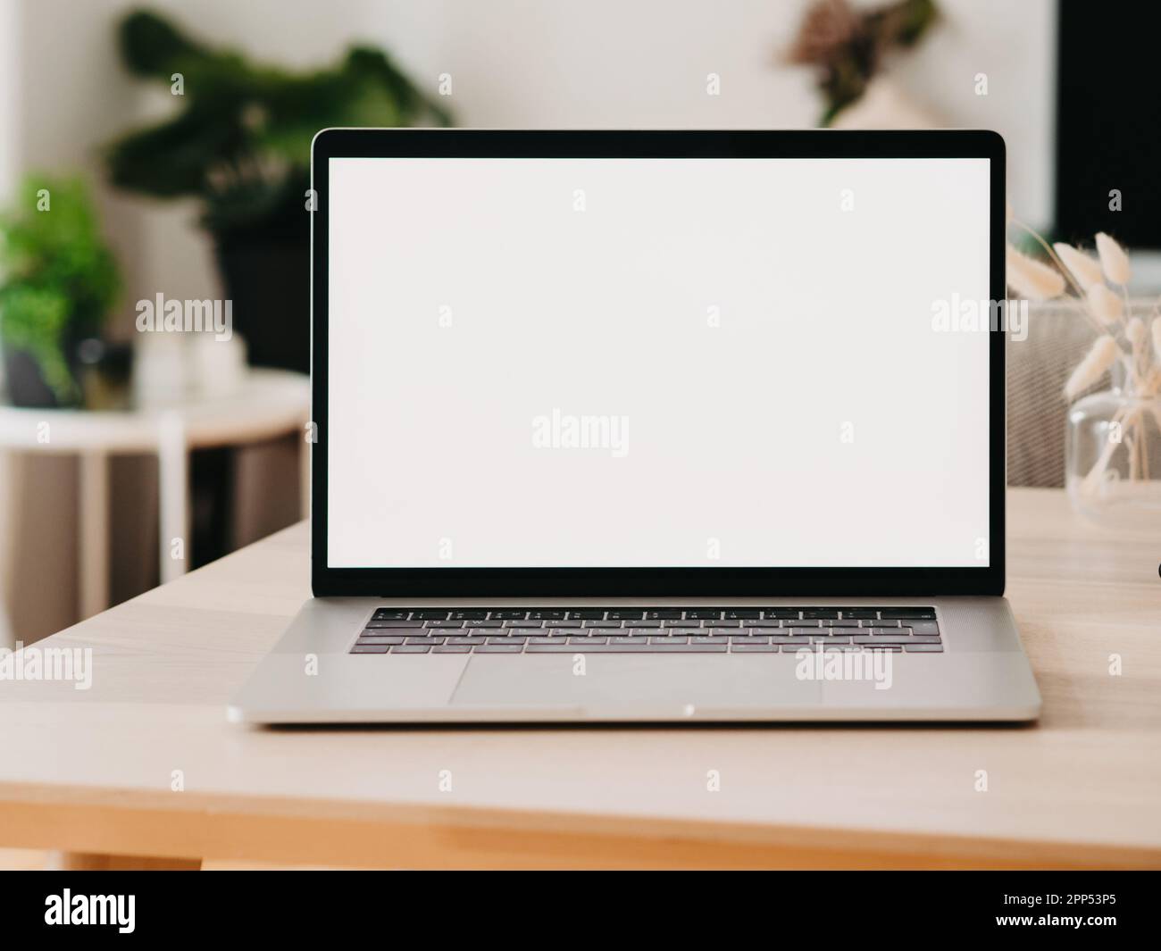 Laptop with blank screen on wooden table in home interior. Workplace ...