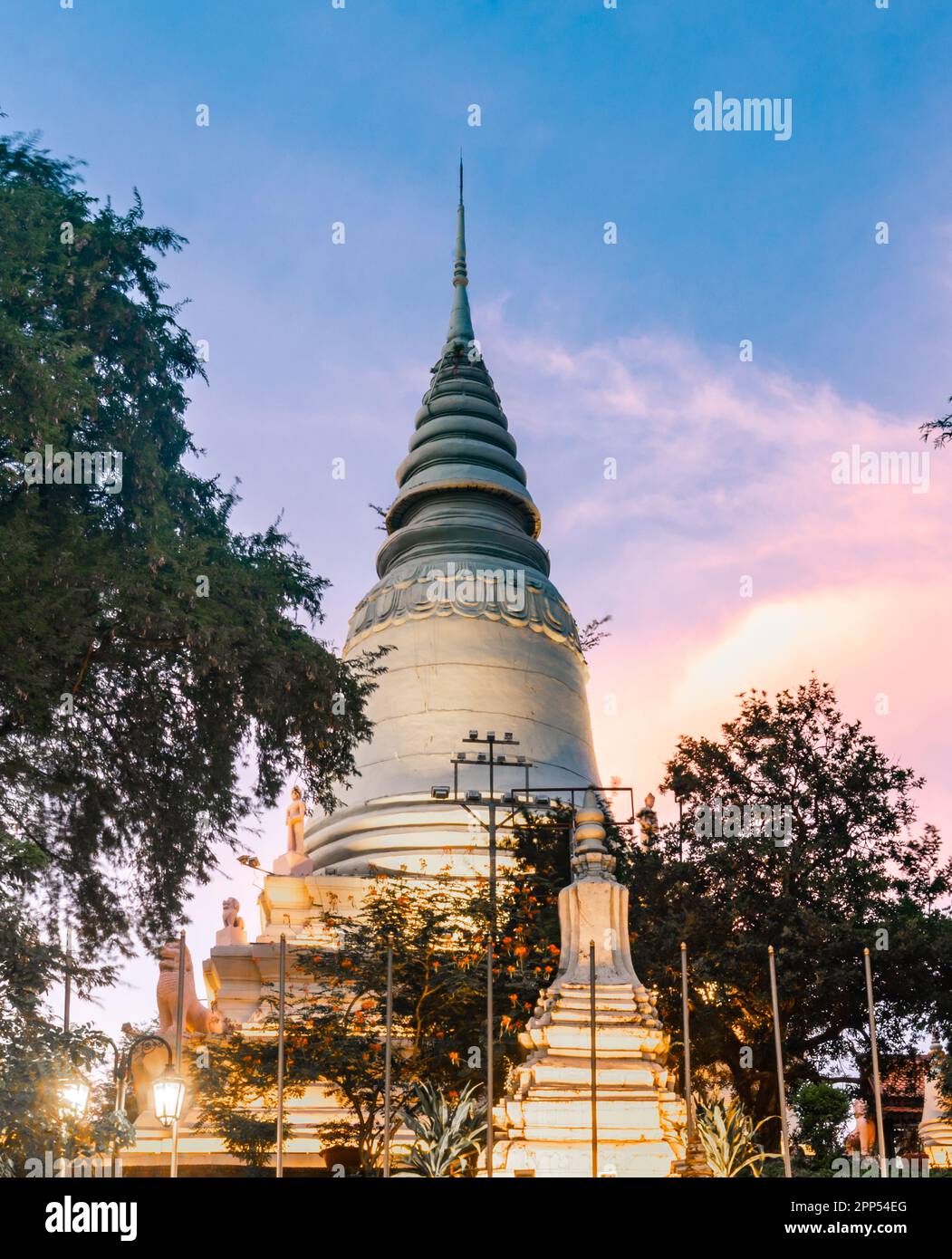In Wat Penh gardens,a gift from China,covered in green grass,a large working clock,beneath the hilltop pagoda of Wat Phnom,a prominent city landmark,n Stock Photo