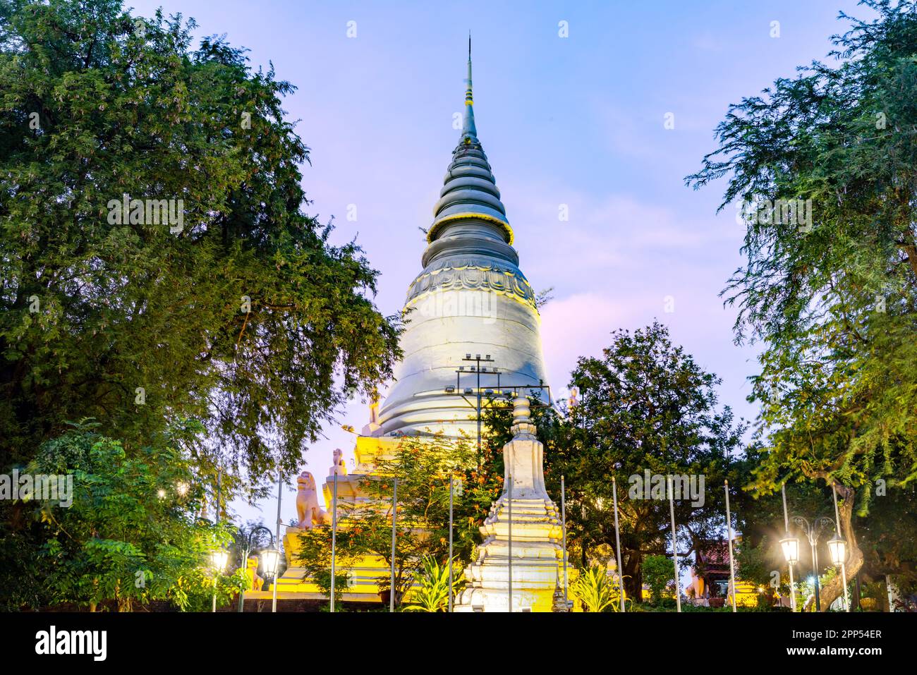 In Wat Penh gardens,a gift from China,covered in green grass,a large working clock,beneath the hilltop pagoda of Wat Phnom,a prominent city landmark,n Stock Photo