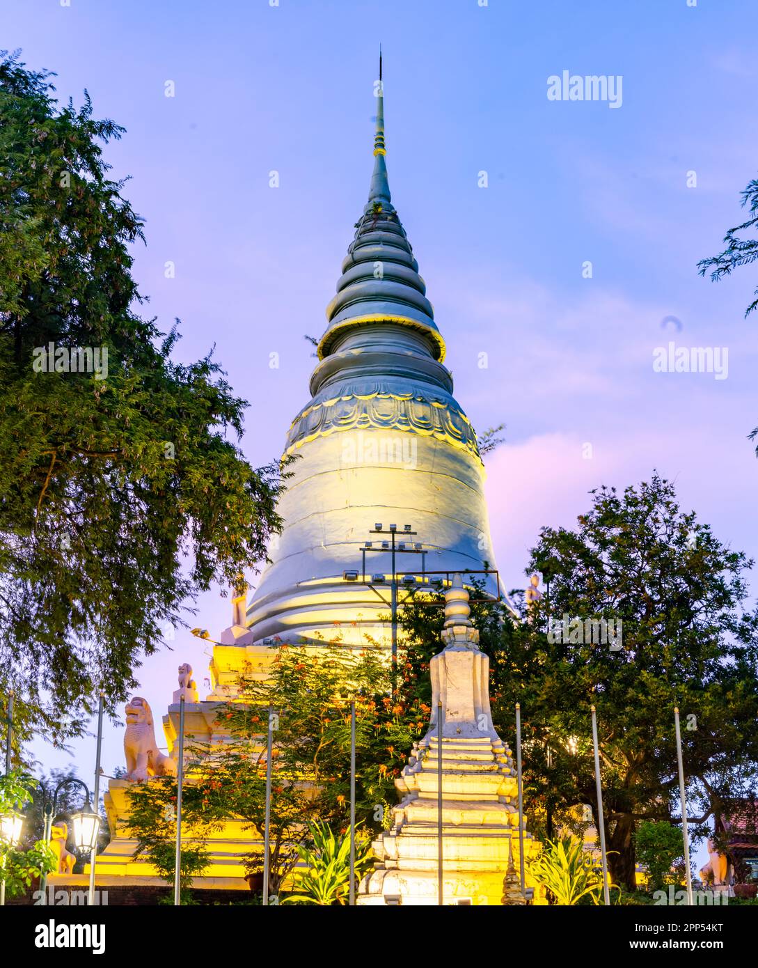 In Wat Penh gardens,a gift from China,covered in green grass,a large working clock,beneath the hilltop pagoda of Wat Phnom,a prominent city landmark,n Stock Photo